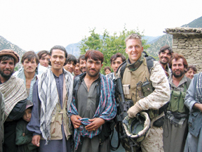 Palisadian Collier Gregory poses with a group of Afghan villagers during combat patrol with his Marine unit. Through an interpreter, villagers bring Gregory intelligence on suspected enemy locations.