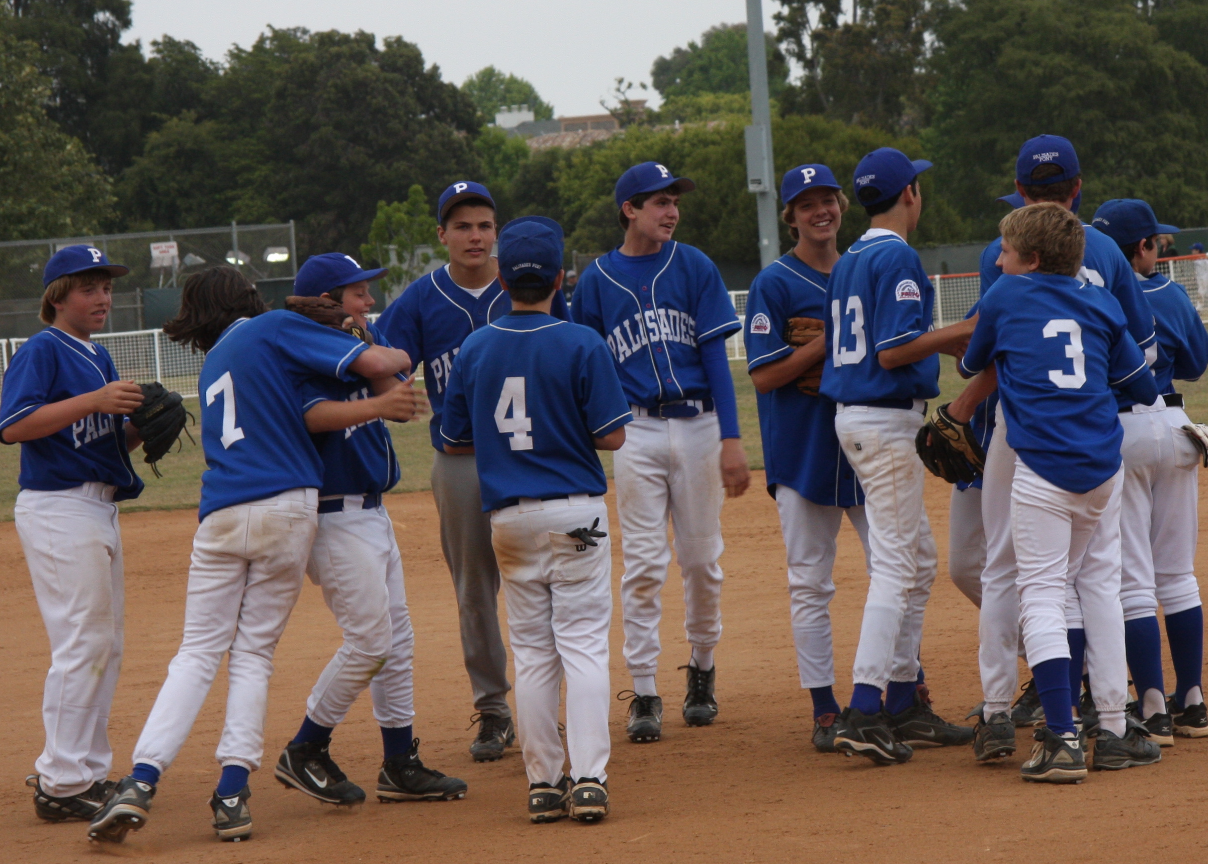 Pali Blue players congratulate each other after winning the Pony Division Championship to finish a perfect 20-0 this season.