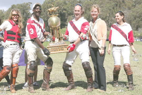 Domingo Questel (#3) and Bolko Kissling (#2) lift the two-goal winner's trophy, joined by teammates Leigh Brecheen (far left),  Hannah Taylor (far right) at Sunday's Chamber of Commerce Polo Tournament.