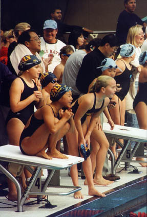 Paly swimmers Mara Silka, Catherine Wang and Olivia Kirkpatrick cheer on teammate Pamela Soffer during the girls' 10-and-under 200 Medley Relay. 		  Photo courtesy of Gayle Kirkpatrick