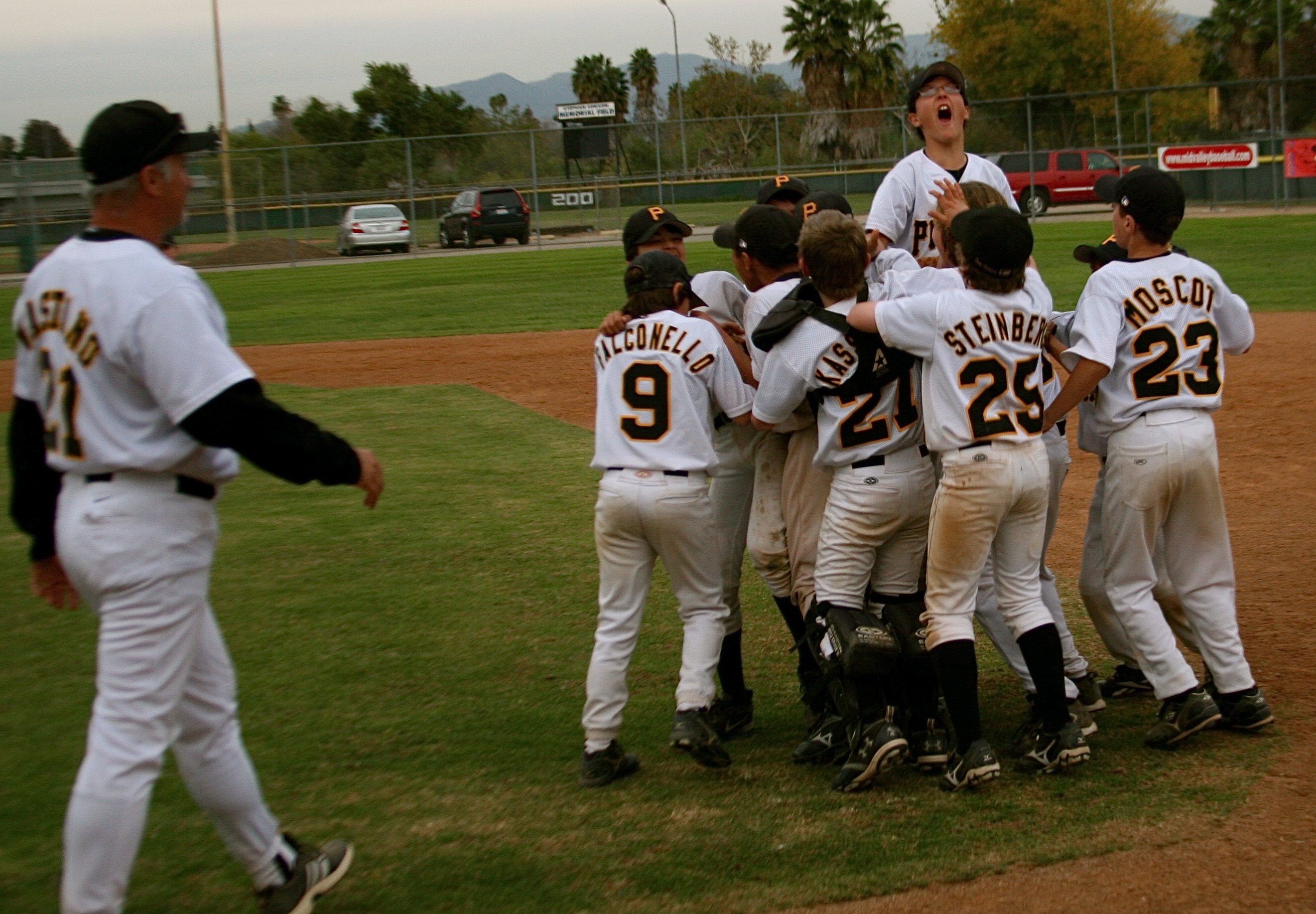 Pirates players celebrate near first base after the final out of last Sunday's Mid-Valley Gobbler championship game. Photo courtesy of Gabi Falconello