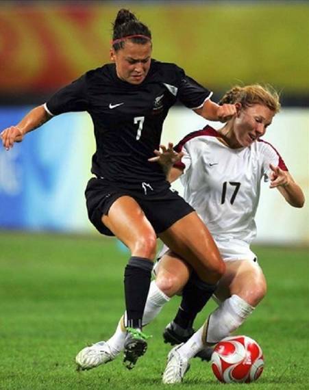 New Zealand's Ali Riley (left) tries to dribble the ball through USA defender Lori Chalupny during group play at the Beijing Olympics August 12 in Shenyang, China.