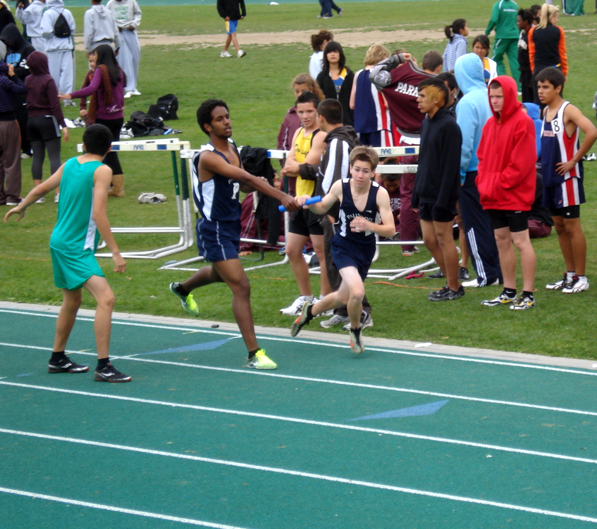 Sahar Micheal (left) hands off the baton to Palisades High teammate Grant Stromberg during the frosh/soph 4 x 800 relay. Photo courtesy of Carl Stromberg