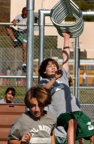 Seventh-graders Cary Jacobson (foreground) and Max Morrison finish the monkey bars portion of the obstacle course at Paul Revere Middle School, which P.E. students began using in January.