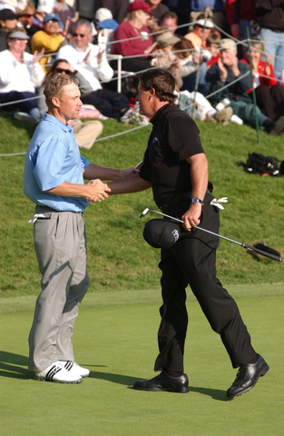 Winner Phil Mickelson shakes hands with playing partner John Rollins on the 18th green at Riviera after the final round last year.