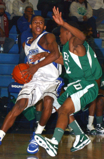 Garrett Nevels looks to drive on Dorsey's Marvin Hall during the Dolphins' 74-65 nonleague victory last Thursday.