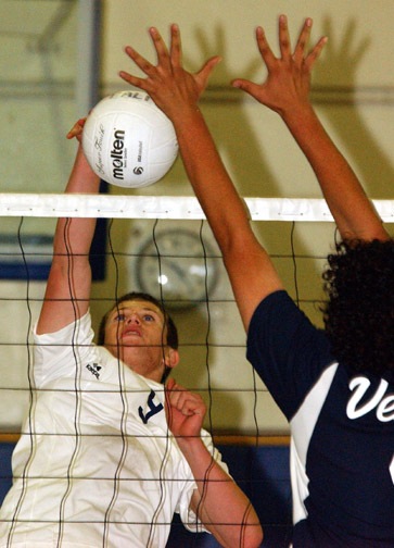 Palisades' Stuart Klein (left) tries to spike the ball past a Venice blocker during last Wednesday's Western League match. The Dolphins lost in four games.