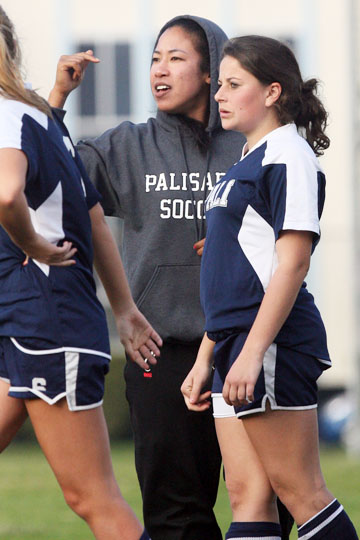 Coach Tianna Oliver waves a player off the field as she waits to substitute Clara Clymer at the Hamilton game, which Palihi won, 3-0.