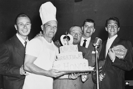 Jerry Lewis (second from right) receives a celebratory cake on his induction as the Honorary Mayor of Pacific Palisades in 1953. His sidekick, Dean Martin, stands by to make sure all goes peacefully, fulfilling his duty as Honorary Chief of Police. Photo: Courtesy Palisades Historical Society