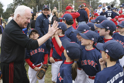 Former L.A. mayor Richard Riordan encourages the Pinto Red Sox, sponsored by his Village Pantry, before their first game Saturday morning at the Field of Dreams.