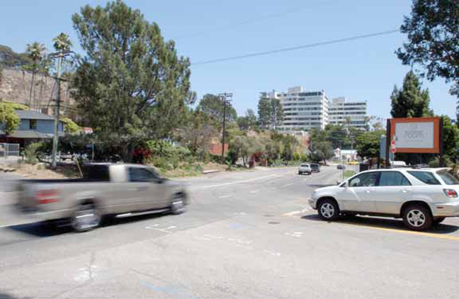 At right, a car navigates turning off Los Liones Drive across from the Westside Waldorf School onto Sunset Boulevard.