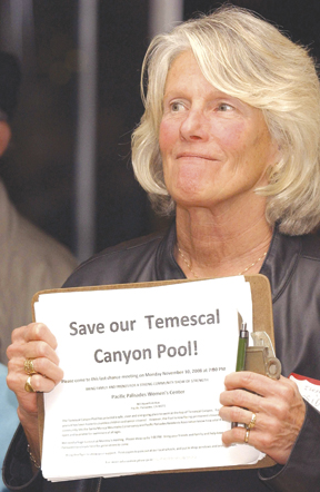 Ilene Cassidy, co-founder of Friends of the Temescal Pool, holds one of the protest signs on display at a Pacific Palisades Residents Association meeting in November.