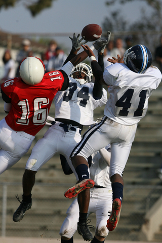 Mychal Creer (34) and Khalid Stevens try to knock the ball away from a Westchester receiver in the Dolphins' 24-3 loss Friday.