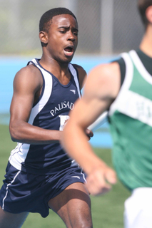Malik McDaniel sprints with the baton in the first leg of the boys' 4 x 100 relay last Friday at Stadium by the Sea.