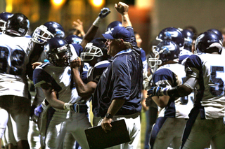 Palisades Coach Kelly Loftus rejoices with his players after the Dolphins' 20-15 victory last Friday night at University High.