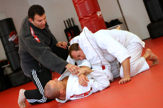 Instructor James Gavsie teaches proper technique to students Alex Ercoli (left) and Kevin Stolper during a Brazilian Jiu-Jitsu class at MAX Impact.