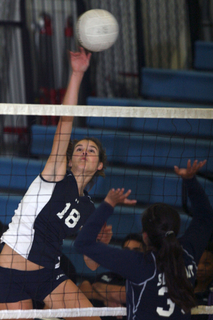 Palisades' senior captain Lauren Gustafson hits through a South East block in Monday' City playoff match. The Dolphins swept 25-10, 25-5, 25-14.