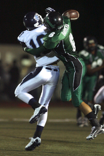 Kevin Mann (left) tries to catch the ball despite being hit by Highlanders' defensive back Jovan Barrera in the third quarter of Palisades' 28-21 loss at John Elway Stadium.