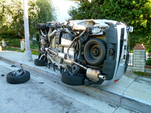 This Honda Pilot was hit with such force that it lost its left rear wheel assembly and was pushed onto the sidewalk at the entrance to Palisades Villas in the Highlands. Photo: Arthur Hoyle