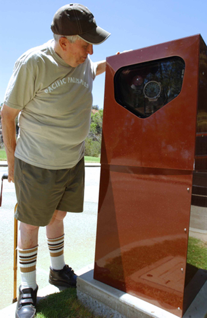 Jack Allen examines the stop-sign camera, which is housed in a cabinet in a parking lot in Temescal Gateway Park. Allen argues the Mountains Recreation and Conservation Authority (MRCA) violated the state Vehicle Code in an attempt to raise revenue.
