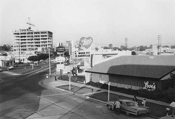 The Brentwood intersection of San Vicente Boulevard and Gorham Avenue in the 1960s, and as it appears today. Hugh Reeves, who, in 1936, co-founded the Evans and Reeves nursery, supplied the coral trees planted across Brentwood