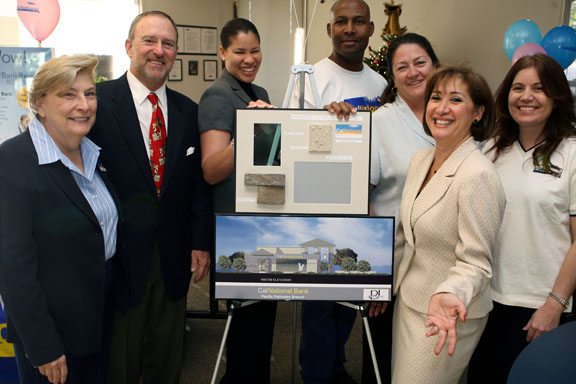 At a Customer Appreciation Day in mid-December, CalNational Bank manager Zara Guivi (second from right) unveils renderings of the bank's new Palisades building. From left, Lois Globnick, Lester Wood, Karetta Anderson, Willie Swain, Lynne Pizzia, Guivi and Diana Gramaje.