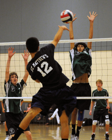 St. Matthew's Hudson Ling drills a spike and Sam Van Dalsem of Calvary Chrisitan goes for the block in the league final on May 12.