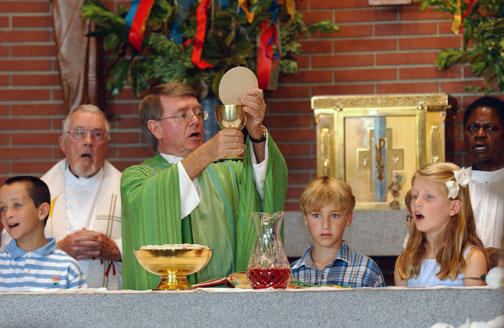 Parishioners celebrated the 60th anniversary of Corpus Christi Church and School on Sunday with a special Mass of Thanksgiving. Here, Msgr. Liam Kidney is joined at the altar by Msgr. Carl Bell (back left), former associate pastor at Corpus Christi, and Msgr. Richard Affrim, current associate pastor, plus Corpus students Ryan Kennedy (left), Dillon Klein and Kerry Keefe as they sing the Great Amen during the part of the Mass called the Consecration. Rich Schmitt/Staff Photographer