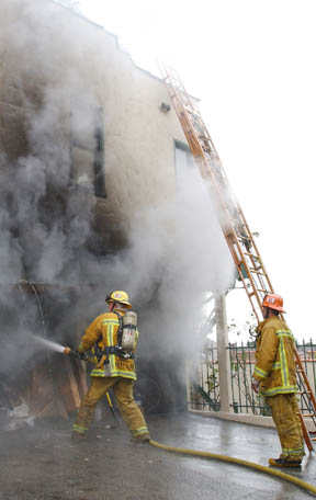 Firefighters tackle the blaze that broke out on Monday afternoon behind the Methodist preschool at Bowdoin and Via de la Paz.