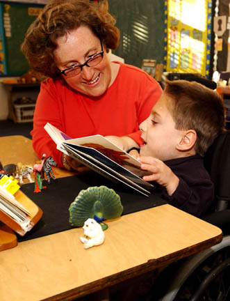 Bethany Stark helps her son Julian, who is blind, feel the Braille dots on a page of 