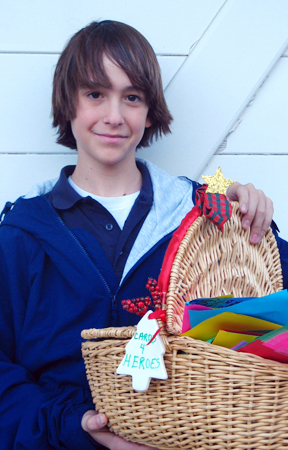 Eighth grader Joseph Elder holds a basket of homemade holiday cards that were sent to soldiers in December.