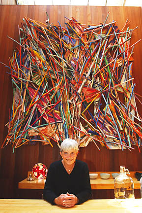Dallas Price-Van Breda sits before a work entitled 