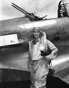 Loran Smith, then about 23, holds his 35-millimeter movie camera while aboard the USS Essex aircraft carrier in the Pacific in 1943. He poses in front of a Douglas dive bomber that was built in Santa Monica.