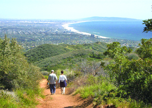 Hikers stroll across Temescal Ridge Trail with a clear view of the Queen's Necklace and Santa Monica Bay. Photo by Jim Kenney