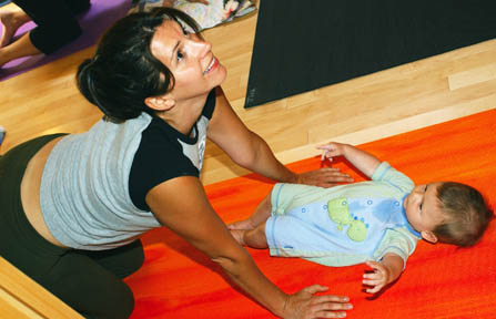 Six-month-old Zachary Haas watches as his mother, Claire, performs cat's tilt in Patti Asad's Mommy & Me class at JIVA Yoga Studio.