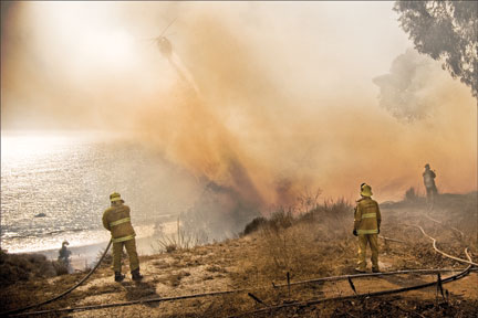 Water-dropping helicopters made many passes on the four-acre fire that burned from Pacific Coast Highway to the top of the bluff at Corona del Mar Saturday. Photo: Robert Larson 