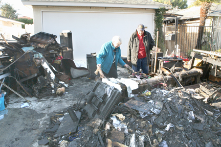 Alice and Robert Scheiperpeter comb through the remains of the contents of their family room after a Friday night fire destroyed half of their house on Sunset Blvd.