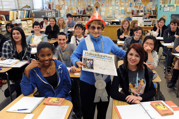 English teacher Rose Gilbert, wearing her infamous plastic firefighter helmet, poses with her students and a copy of the Palisadian-Post after learning that she has been named Citizen of the Year.