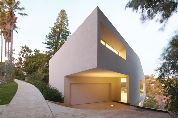 The Hill House, as seen here from Chautauqua Boulevard, juts out above Sunset Boulevard above Rustic Canyon. Supported by caissons, the three-story structure seems to hang effortlessly on the hillside, with the canyon face of the house having the appearance of a suspended prow. The sculptural quality of the house is enhanced by a lavender-tinged exterior coating that stretches over the structure uniformly like a skin. Photo: Eric Staudenmaier, courtesy of Johnston Marklee & Associates