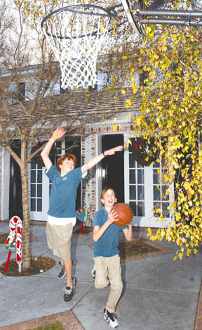 Trevor Henney, 10, drives to the basket against his brother D.B., 13, as they once again enjoy playing hoops in their Highlands driveway.
