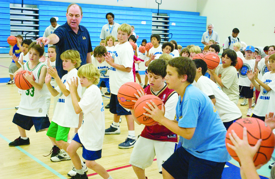 UCLA men's basketball coach Ben Howland teaches proper shooting technique to kids at his youth basketball camp Monday at Palisades High.