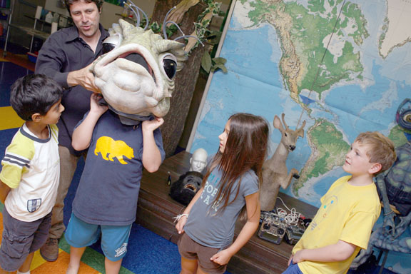 At IDEAS Studio, Peter Chevako fits a student with the deep sea creature's head, while fellow students, from left, Chloe Hartog, Tommy Bufigliano and Carley Bell look on.