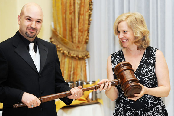 Signifying the figurative passing of the torch, incoming Chamber of Commerce president Ramis Sadrieh receives an oversized gavel from outgoing president Antonia Balfour.