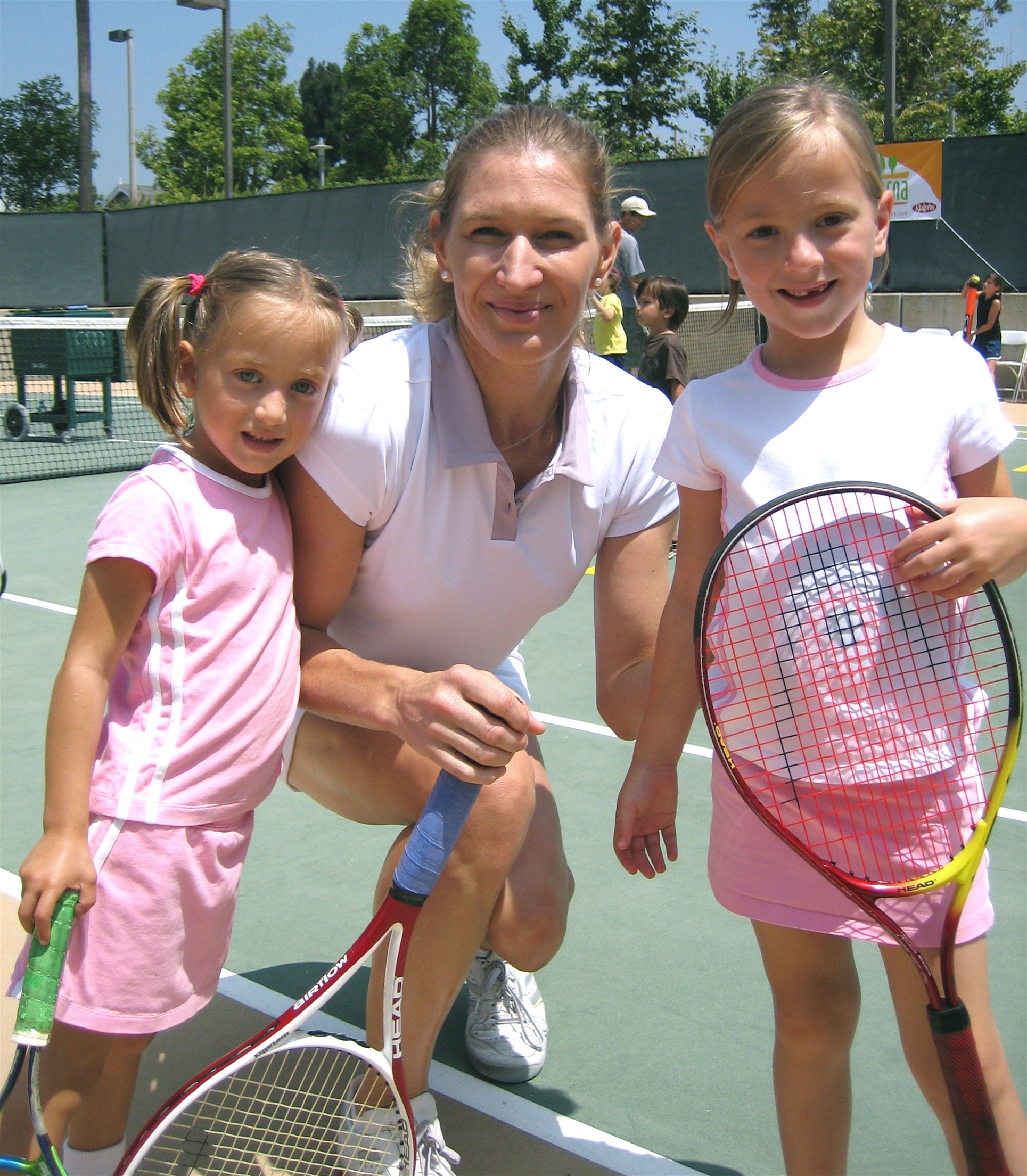 Steffi Graf shares a smile with Pacific Palisades sisters Morgan (left) and Kylie Greenwald at an Eaturna tennis clinic July 31 in Santa Monica. Photo: Shelley Greenwald