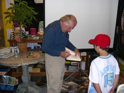 Author Howard Frank Mosher autographs a copy of 