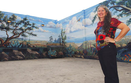 Palisades artist Terri Bromberg stands in front of the Clearwater mural addition she recently completed on the Sav-on loading dock on Swarthmore.