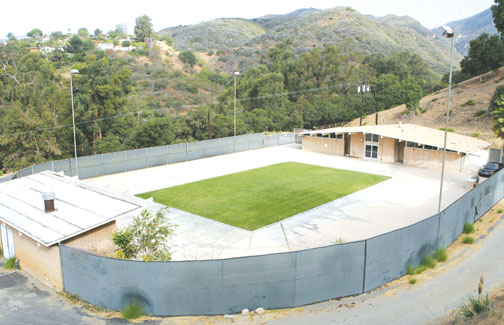 The former YMCA-operated swimming pool in Temescal Canyon, filled in by the Santa Monica Mountains Conservancy in January, now looks like a grass court for tennis as Friends of Temescal Pool seeks a solution that will restore the pool as a public facility.