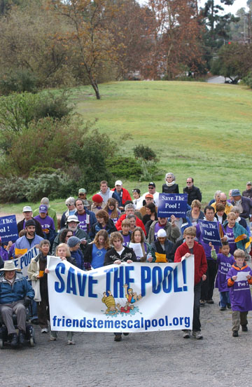 About 100 Pacific Palisades residents hold hands around the Temescal Canyon pool on Saturday to protest the Santa Monica Mountains Conservancy