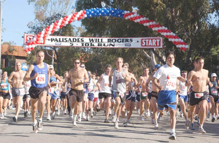 Runners pound the pavement on the corner of Alma Real and Toyopa Drives at the start of last year's Palisades-Will Rogers 5K/10K race. Palisades High alum Peter Gilmore (at left wearing #429) set a new 5K course record last year.