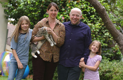 Producer Edward Saxon, who calls himself a family guy, is pictured with daughters Violet (left) and Willow, and wife Kirsten Coyne, holding their pet cat Quinn.